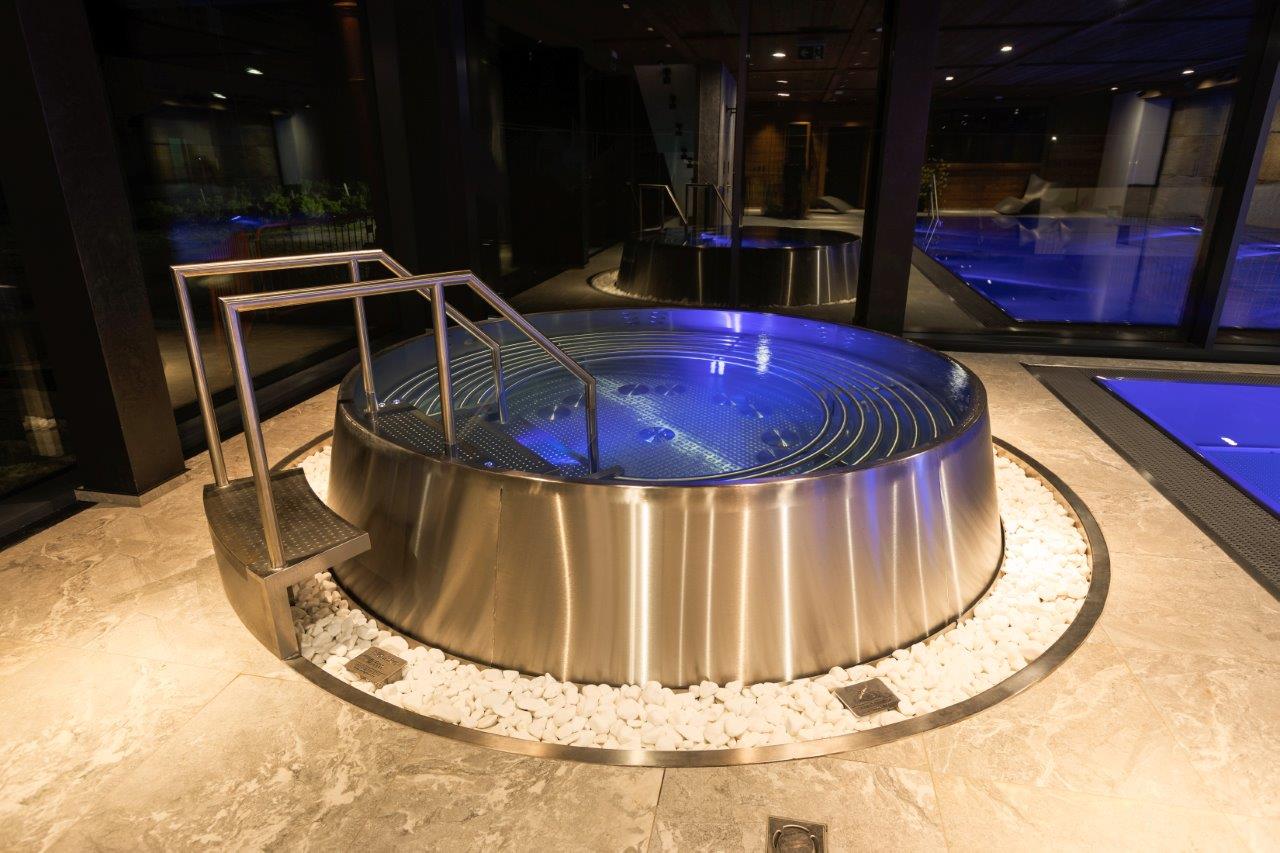 Tanque circular em inox integrado numa zona de spa. Referência de instalação.