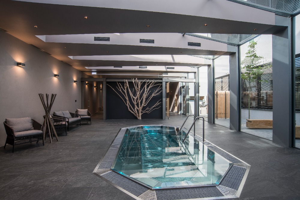 Piscina interior em inox integrada na arquitetura. Referência de espaço wellness.