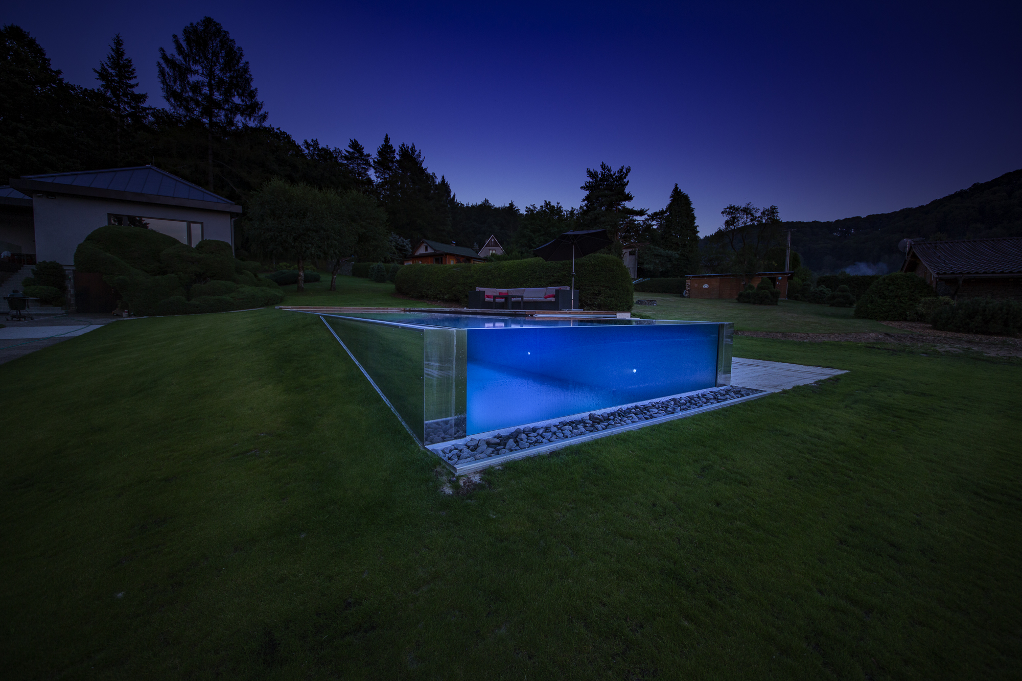 Piscina em inox integrada num jardim. Referência de instalação exterior.
